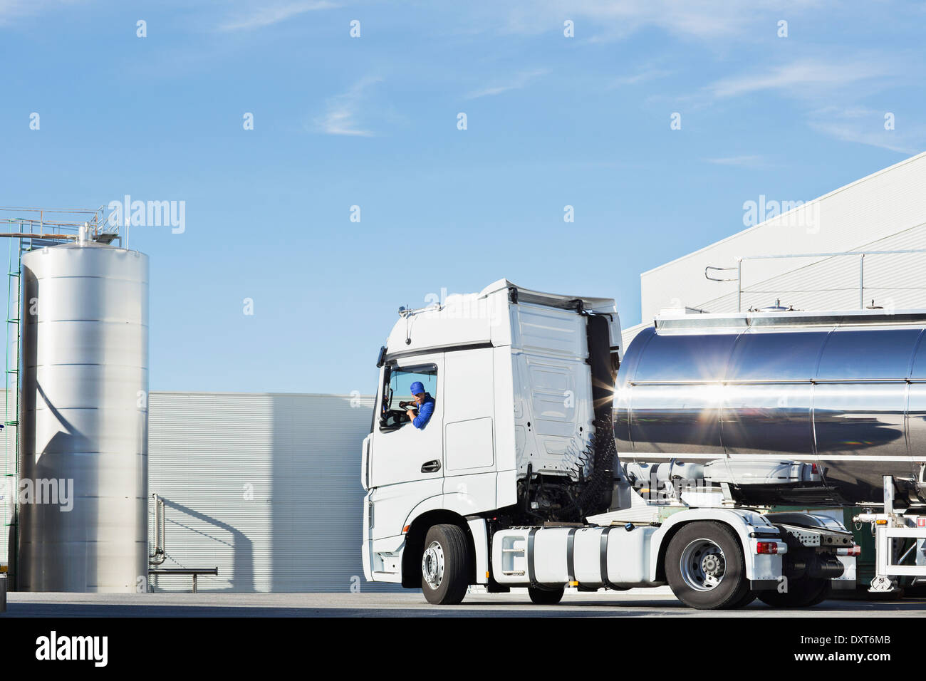 LKW-Fahrer, die Silage Lagerung Turm Edelstahl Milch Tanker Aussenparkplatz Stockfoto