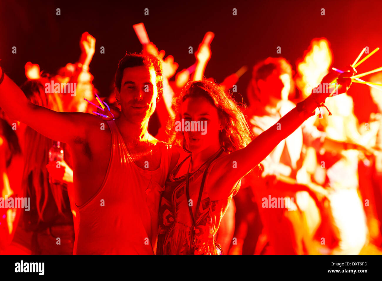 Porträt des Paares mit Leuchtstäben tanzen beim Musikfestival Stockfoto