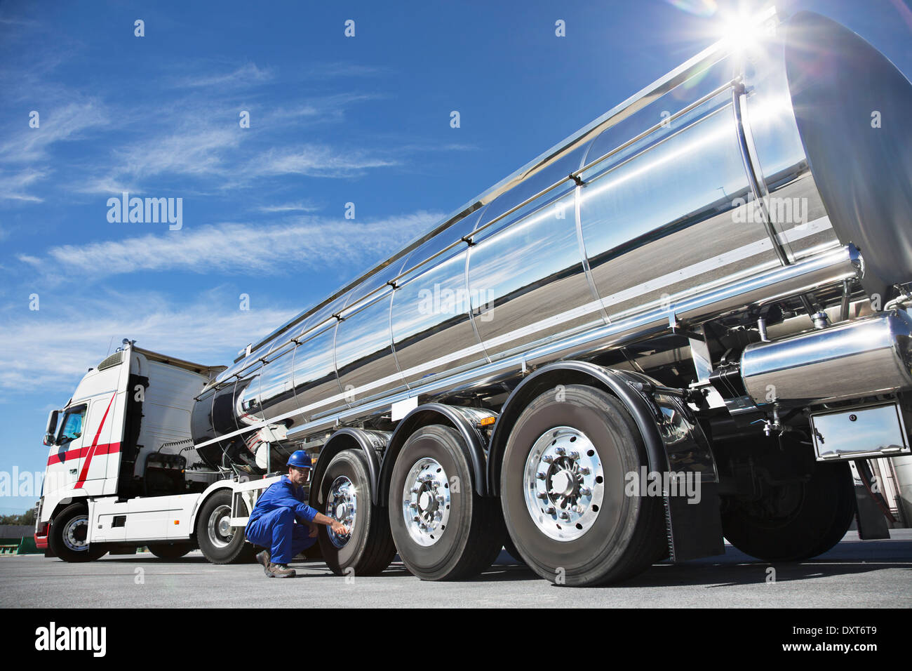 Arbeiter, die Überprüfung der Reifen auf Edelstahl Milch tanker Stockfoto