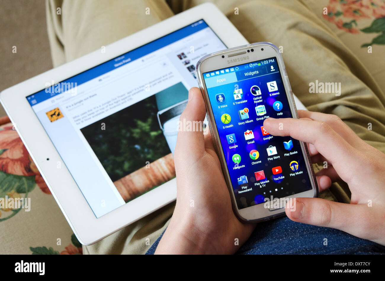 Teenager mit ein smart Phone und einem Ipad gleichzeitig mit Stockfoto