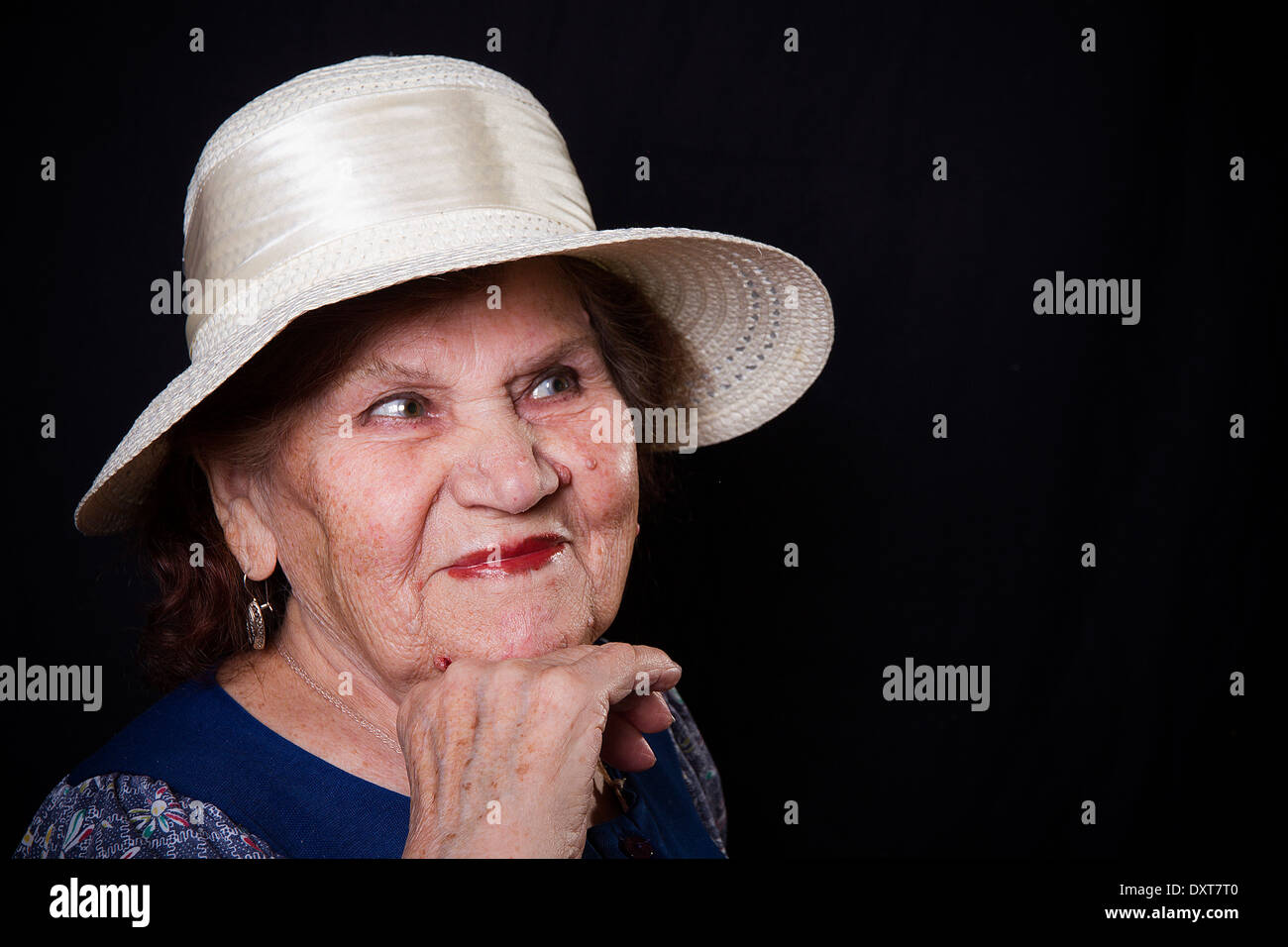 Porträt der alten Frau mit einem Hut auf einem schwarzen Hintergrund Stockfoto