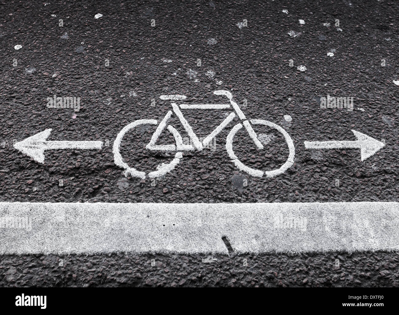 Fahrradweg. Weiße Straßenmarkierung mit Pfeilen auf dunklem asphalt Stockfoto