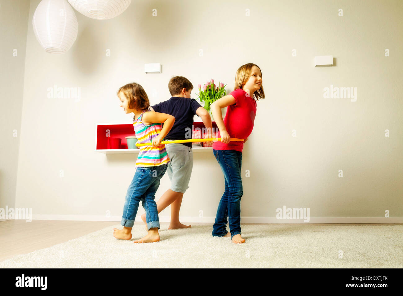 Kinder im Wohnzimmer mit Hula hoop zusammen, München, Bayern, Deutschland Stockfoto