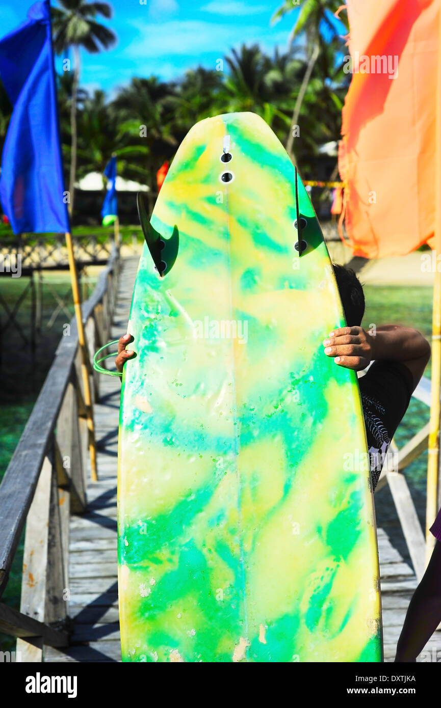 Junger Mann zu Fuß mit einer Surfbretter bei Cloud 9 Surfpoint auf Siargao Island, Philippinen Stockfoto