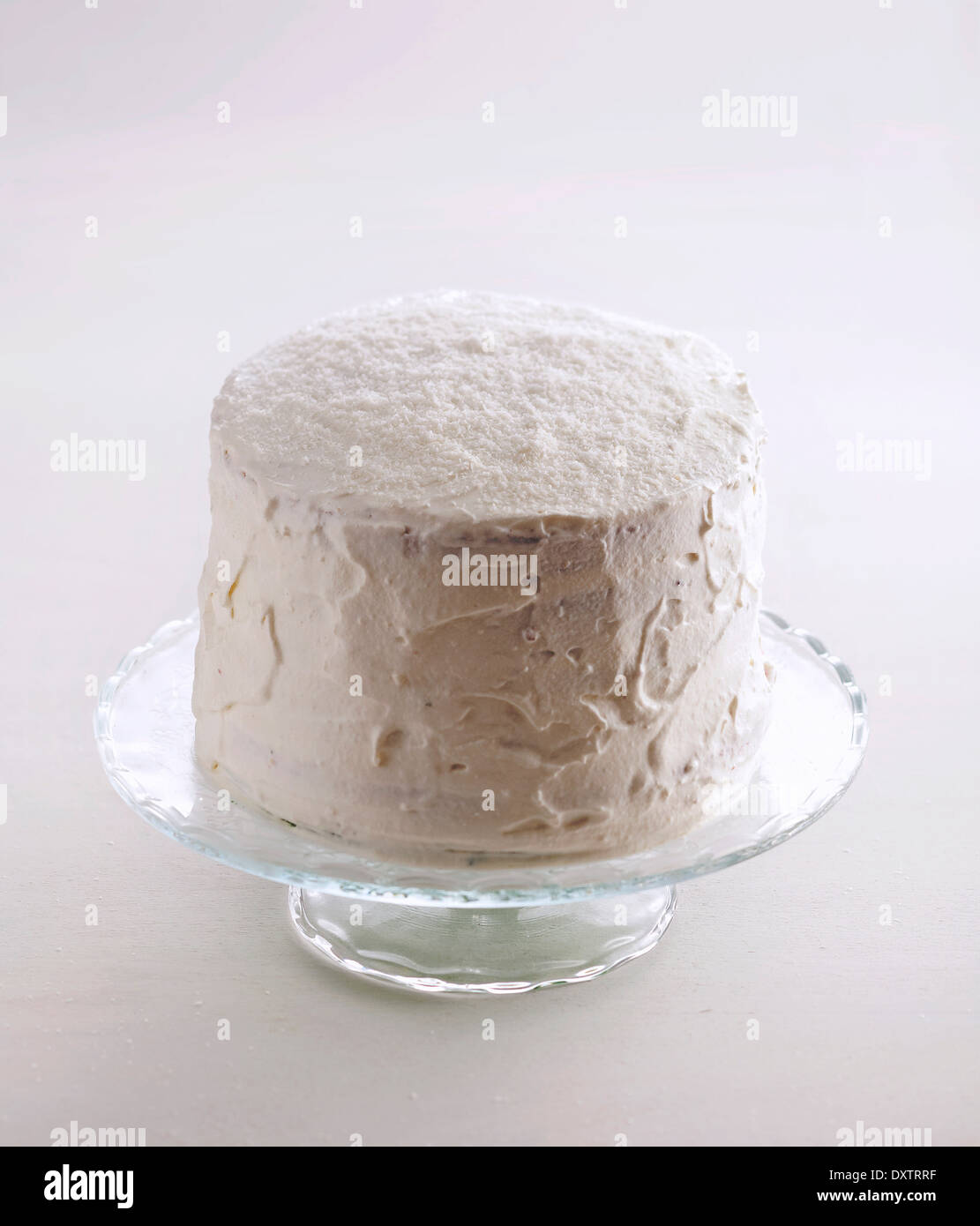 Den Kuchen mit Sahne und geriebene Kokosnuss Beschichtung Stockfoto