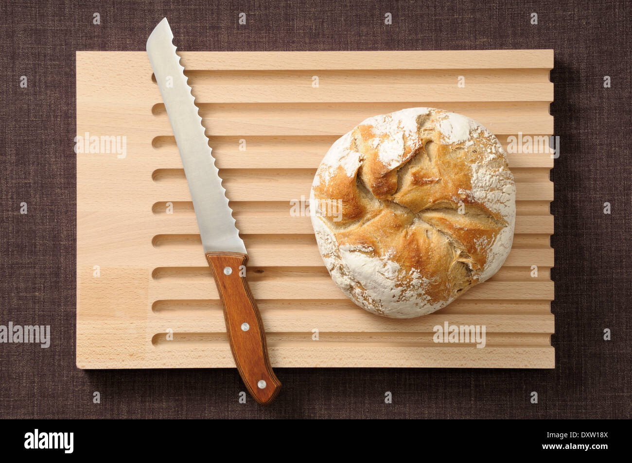 Rundes Laib Brot auf einem Schneidebrett Stockfoto