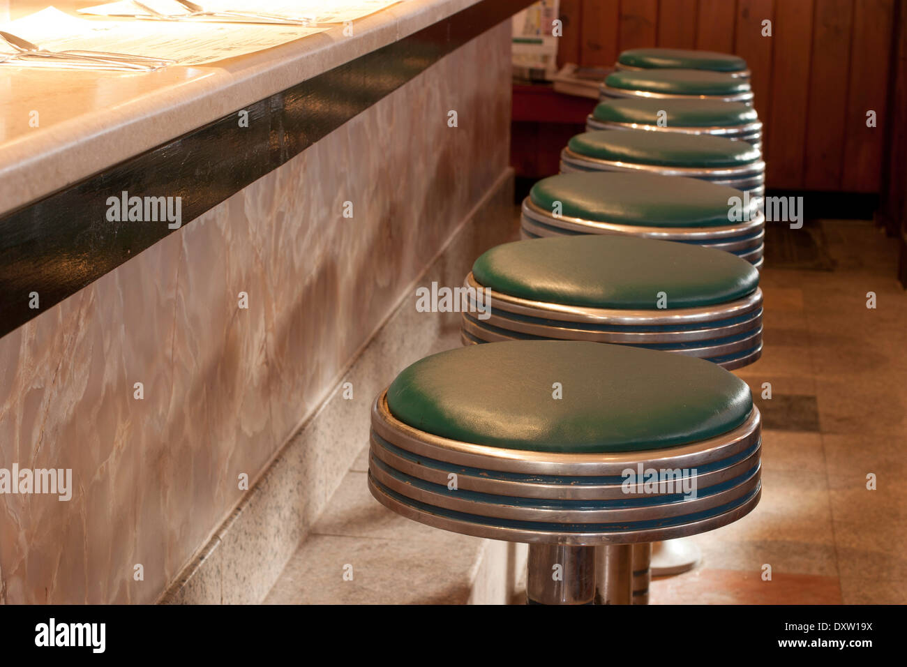 Leere grüne Stühle Line-up vor dem Diner-Schalter. Stockfoto