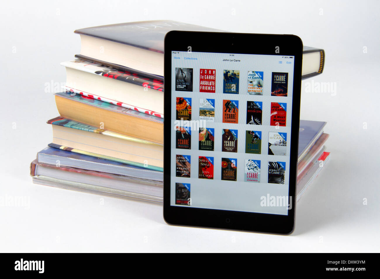 Apple iPad Mini Anzeige von Icons für 21 Bücher mit einem Stack von nur 6 bedrucktes Papier-Bücher Stockfoto