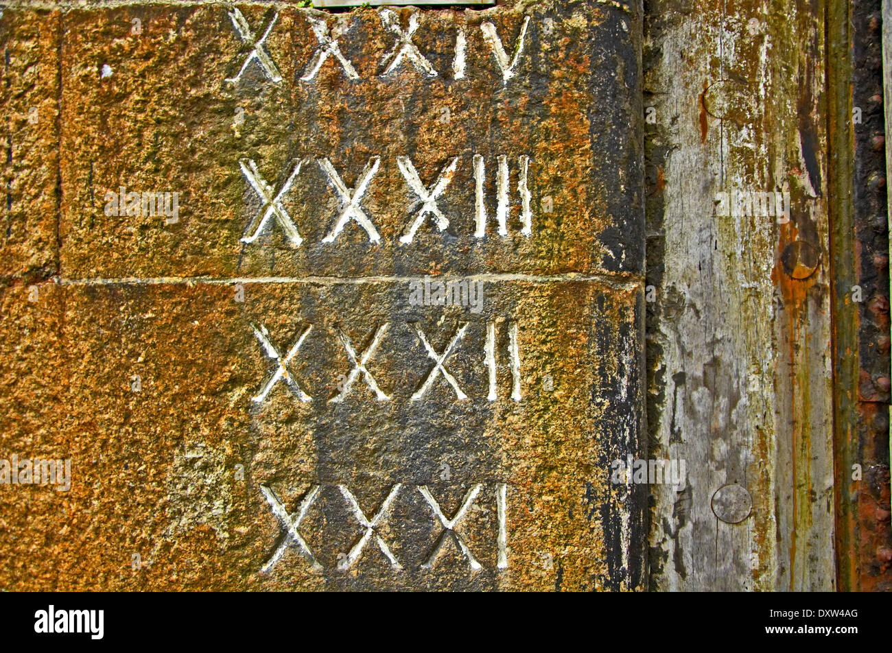 Römische Ziffern in das Mauerwerk der alten Dock Mauern gehauen hat tiefe Wasser Details. Stockfoto
