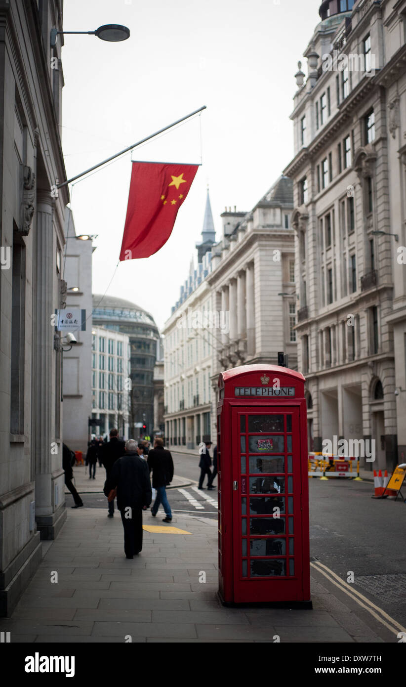 Rote Telefonzelle in der Londoner City mit chinesischen roten Flagge im Hintergrund Stockfoto