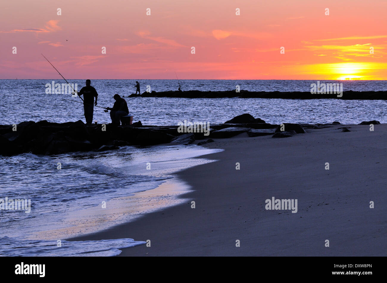 Männer Angeln am Strand bei Sonnenuntergang in Cape May, NJ, USA Stockfoto