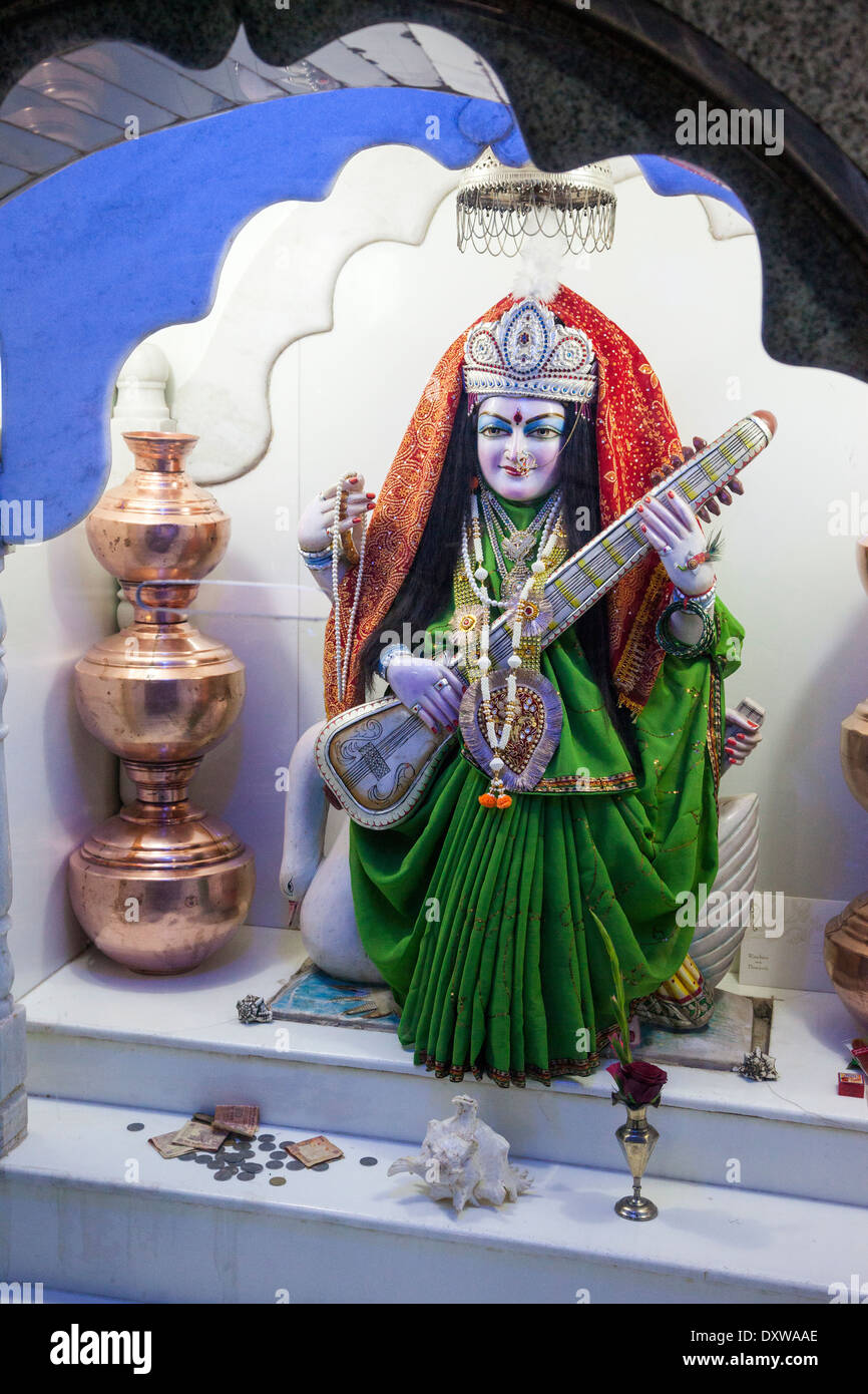 Indien, Dehradun. Tapkeshwar-Hindu-Tempel. Saraswati Göttin der Bildung Musik und Kultur hält ein Veena, ein Saiteninstrument. Stockfoto