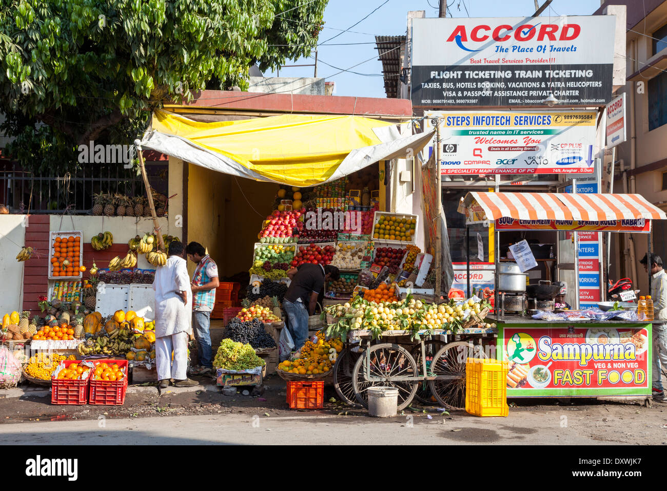Indien, Dehradun. Straßenszene - Fast-Food, Obst stehen, Reisebüro. Stockfoto