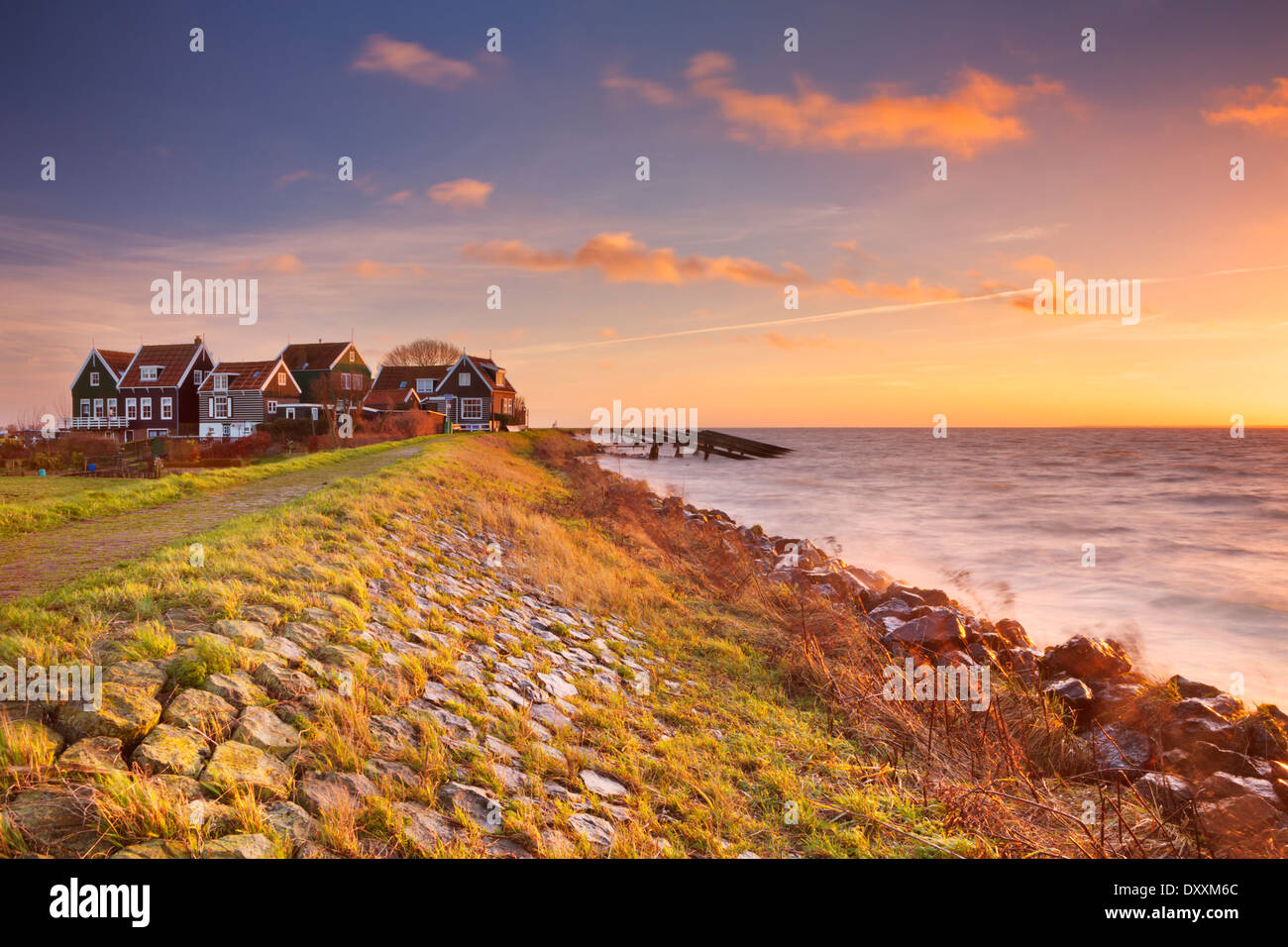 Kleines Dorf hinter einem Deich, fotografiert auf der Insel Marken in den Niederlanden bei Sonnenaufgang Stockfoto