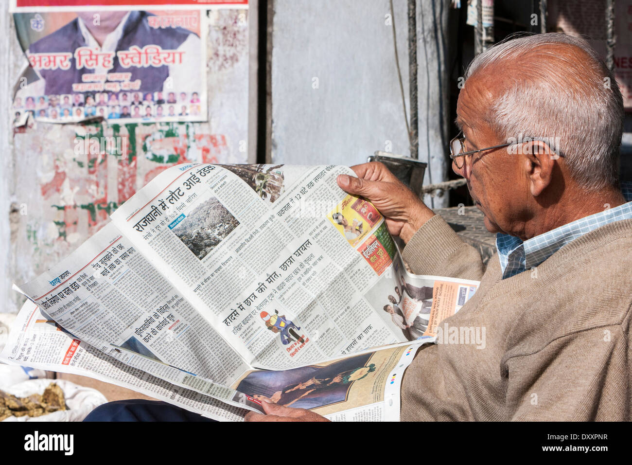 Indien, Dehradun. Mann liest seine Morgenzeitung in Hindi. Stockfoto