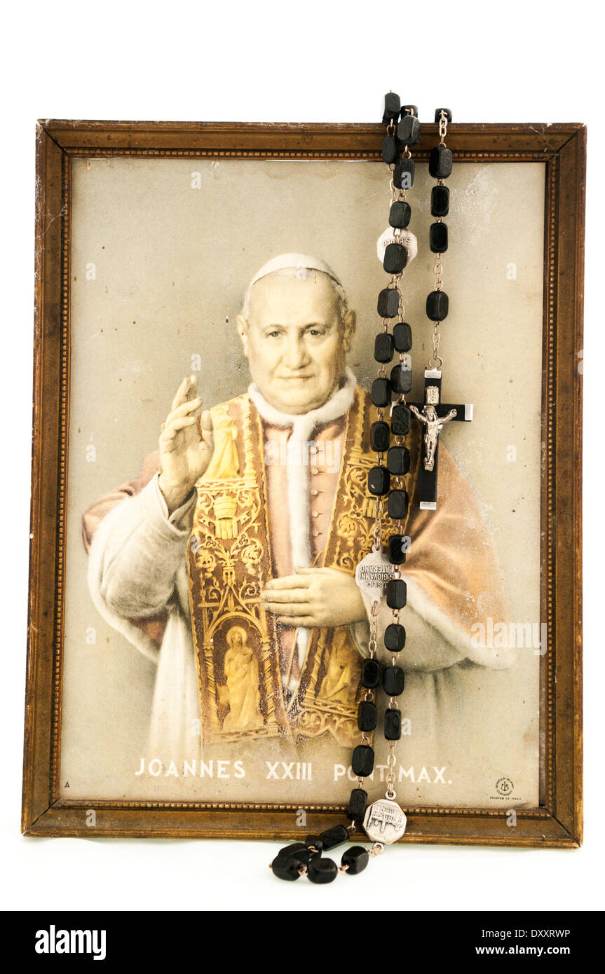 Neue Rosenkranz drapiert über einen alten, schmutzigen Bild von Papst John XXIII.   Ausschnitt auf weißem Hintergrund. Stockfoto