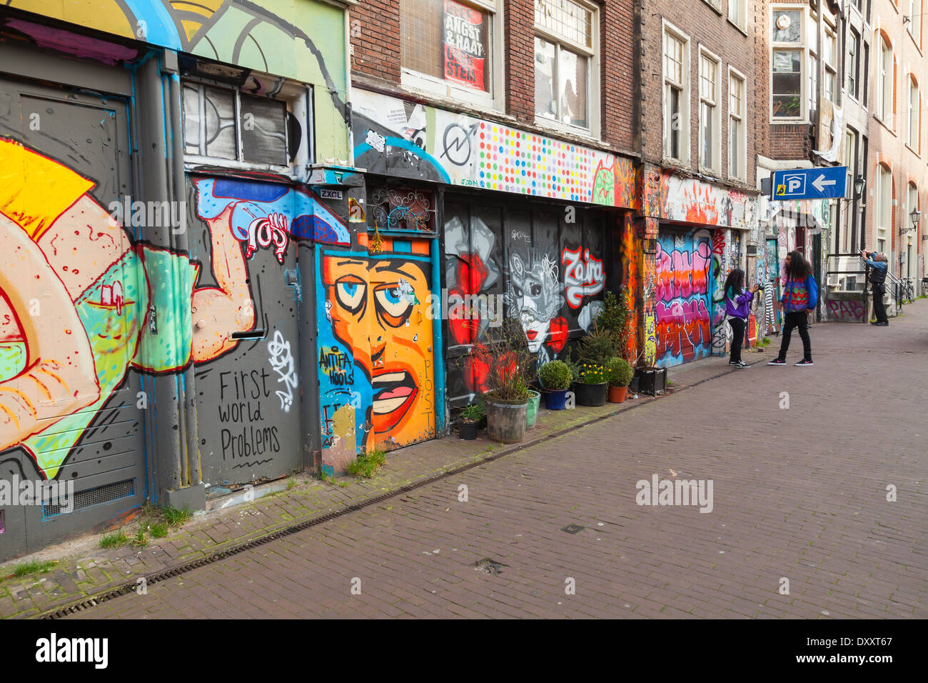 AMSTERDAM, Niederlande - 19. März 2014: Straße mit bunten Graffiti an Gebäudefassaden Stockfoto