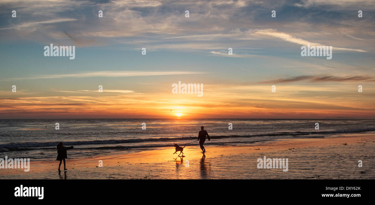 Mensch und Hund genießen Sie den Sonnenuntergang auf dem hundefreundlichen Leo Carillo State Beach in Süd-Kalifornien Stockfoto