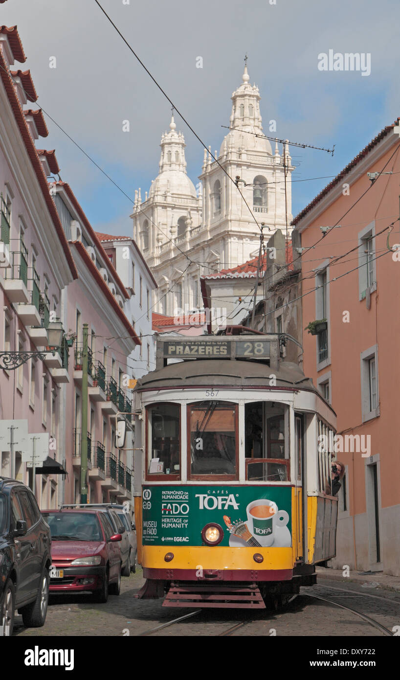 Straßenbahn Nr. 28, Prazeres mit Paróquia de São Vicente de Fora (Kloster von São Vicente de Fora) hinter in Lissabon, Portugal. Stockfoto