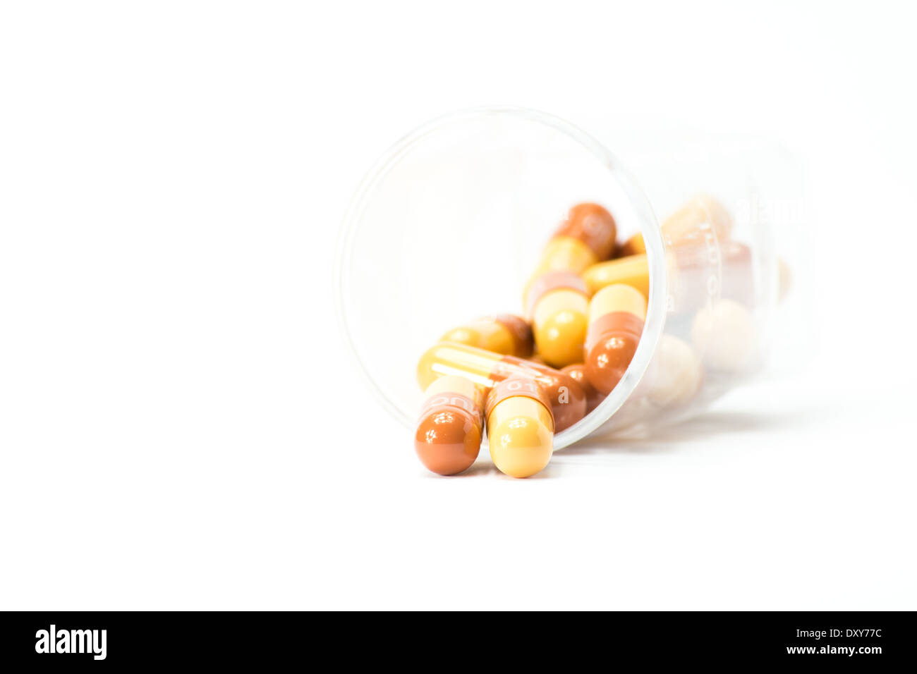 roten und gelben Pillen aus Container auf weißem Hintergrund Stockfoto