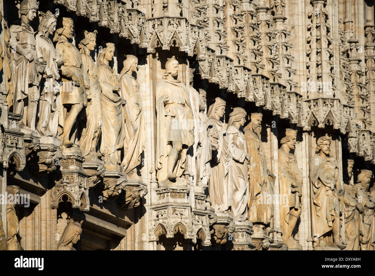 Brüsseler Rathausstatuen Grand Place Brüssel Belgien // BRÜSSEL, Belgien — verzierte Statuen zieren die Außenwände des Brüsseler Rathauses, dem gotischen Meisterwerk, das den Grand Place verankert. Das skulpturale Programm mit historischen Figuren, Heiligen und Adligen repräsentiert jahrhundertelang belgisches künstlerisches Erbe. Diese mittelalterlichen und neogotischen Statuen zeigen die Entwicklung der architektonischen Skulptur in Brüssel. Stockfoto