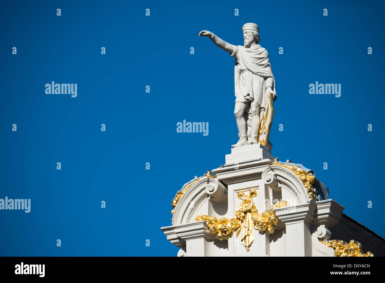 Grand Place Guild House Statue Brüssel Belgien // BRÜSSEL, Belgien — Eine Statue krönt eines der historischen Gebäude auf dem Grand Place, dem zentralen mittelalterlichen Platz von Brüssel. Diese architektonischen Skulpturen, die nach dem französischen Bombardement von 1695 rekonstruiert wurden, zeigen das aufwendige dekorative Programm der Gildenhäuser des Platzes. Die Statue ist Teil des reichen architektonischen Erbes des UNESCO-Weltkulturerbes. Stockfoto