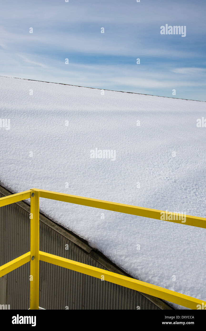 Gelbe Geländer und Schnee bedeckten Dach mit blauem Himmel Stockfoto