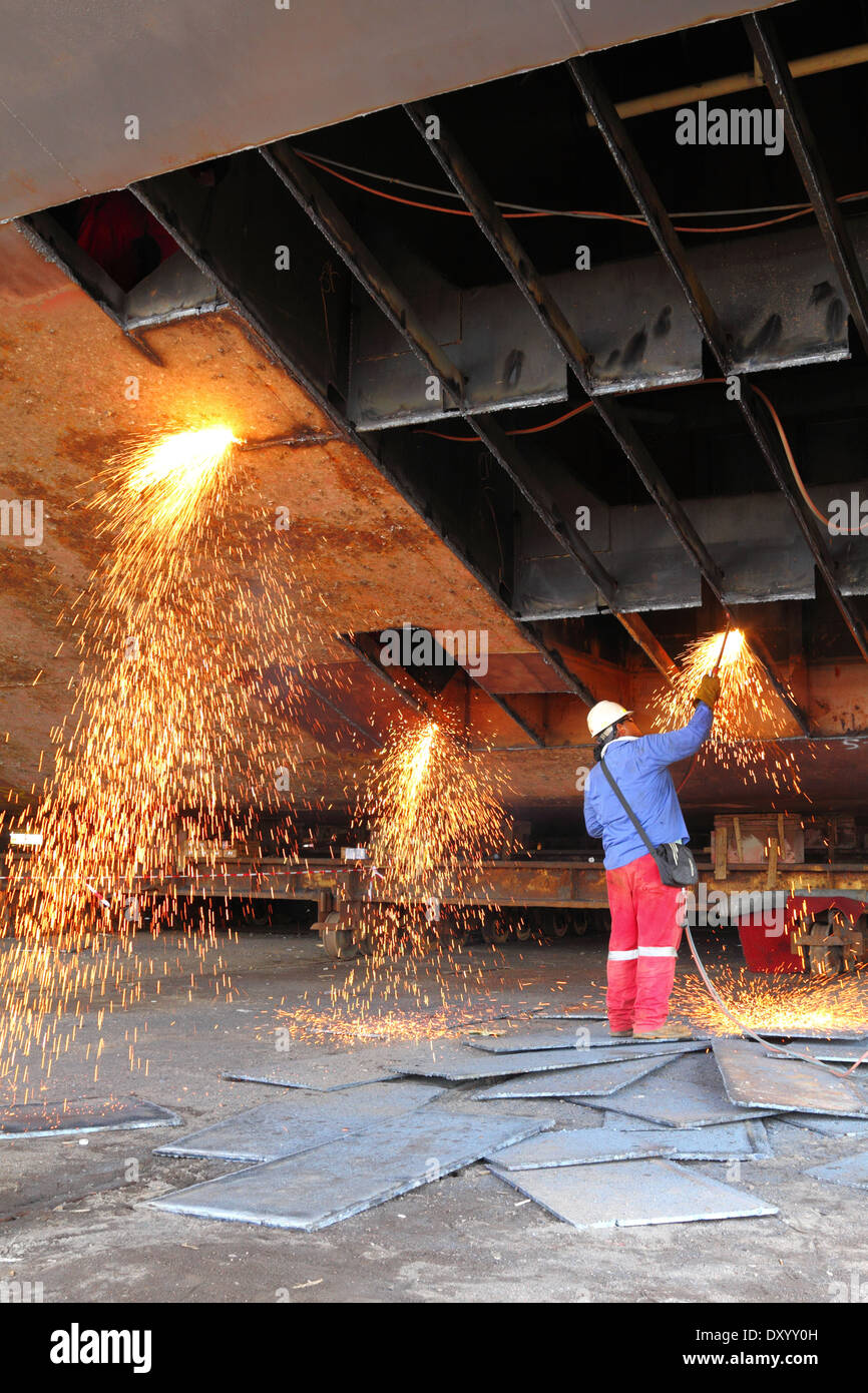 Funken fliegen als Stahl, aus einem alten Lastkahn durch eine Sauerstoff Acetylen-Taschenlampe auf einer Werft in Malaysia geschnitten. Stockfoto