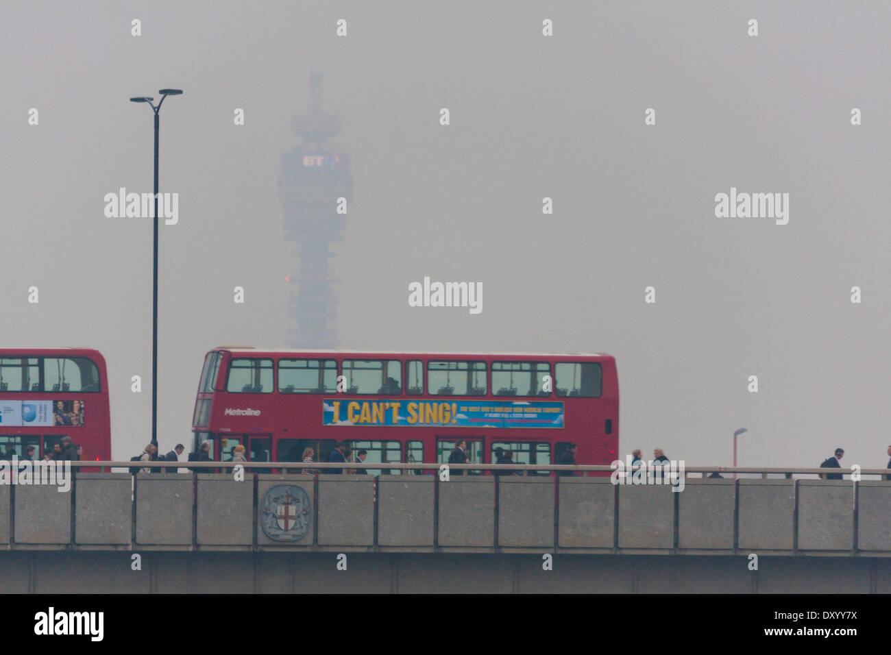 London, 2. April 2014.  Pendler überqueren London Bridge mit dem BT Tower im Hintergrund verdeckt durch Smog als Verunreinigung der Luft durch Europa und Staub aus der Sahara Wüste Sandstürme Drifts über Süd-Ost-England.Pollution Ebene sind auf dem Vormarsch der nächsten Tage. Die schlechte Luftqualität schafft einen Schleier über viel von England. Bildnachweis: Paul Davey/Alamy Live-Nachrichten Stockfoto