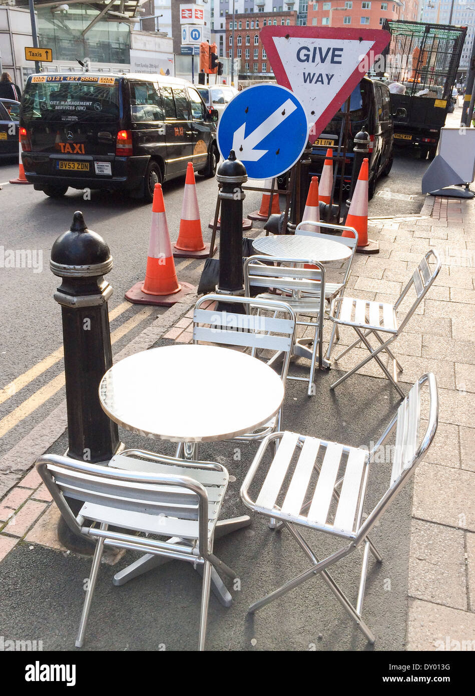 Tische und Stühle neben Straßenarbeiten vor einem Café im Stadtzentrum von Birmingham. Stockfoto