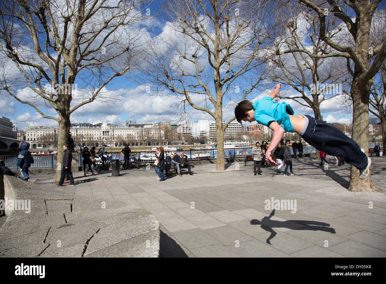 Parkour-Läufer zeigt urban akrobatische Fähigkeiten fliegen kopfüber an der South Bank, London, UK. Stockfoto