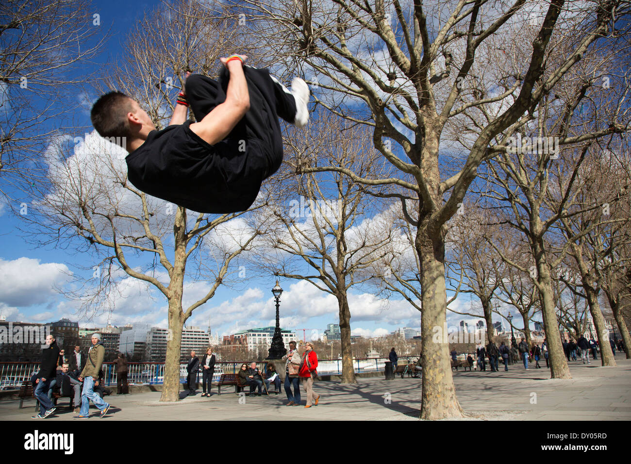Parkour-Läufer zeigt urban akrobatische Fähigkeiten fliegen kopfüber an der South Bank, London, UK. Stockfoto