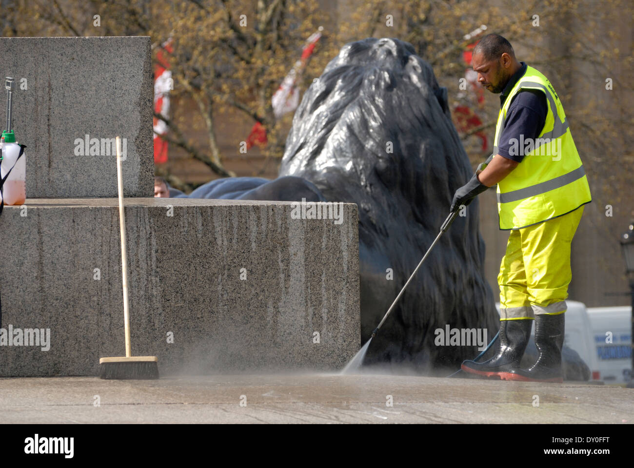 London, England, Vereinigtes Königreich. Arbeiter in hi-Vis-Jacke, die Reinigung der Basis des Nelson Säule mit einem macht-Schlauch Stockfoto