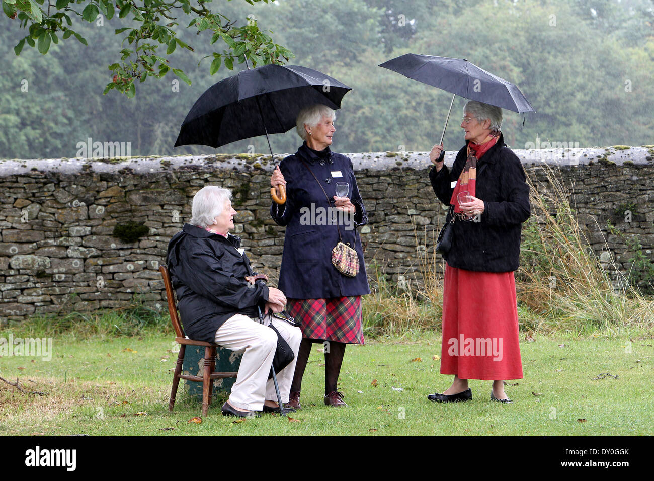 Besucher Unterschlupf vor dem Regen auf einen Empfang im Freien für britische Premierminister David Cameron in seinem Wahlkreis Witney Stockfoto