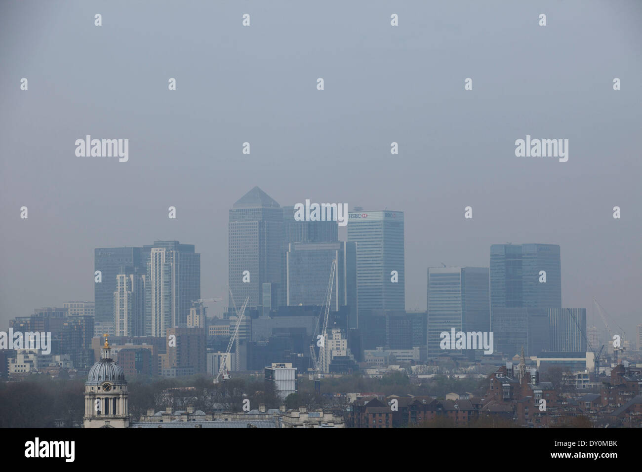 London, UK. 2. April 2014. Umweltverschmutzung durch die Industrie aus Europa und Staub aus der Sahara-Region erzeugt eine Schicht von Smog über der City of London. Kaum sichtbar durch die verschmutzte Luft, scheinen die Gebäude um die schlechte Luftqualität zu verschwinden. Blick vom Greenwich Park in Richtung Skyline bei Canary Wharf Bankenviertel. Bildnachweis: Michael Kemp/Alamy Live-Nachrichten Stockfoto