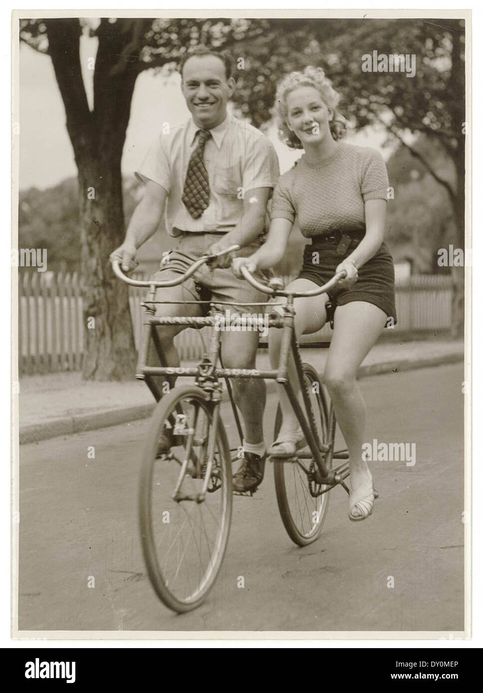 Mann und Frau auf einem Malvern nebeneinander-Tandem-Fahrrad, c. der 1930er Jahre, von Sam Hood Star Stockfoto