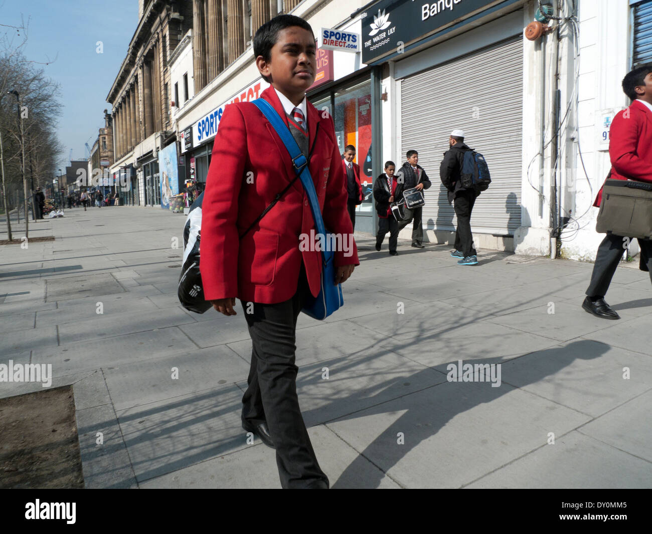 Junge in Uniform zu Fuß zur Schule entlang Mile End Road in Whitechapel East London England Großbritannien Großbritannien KATHY DEWITT Stockfoto