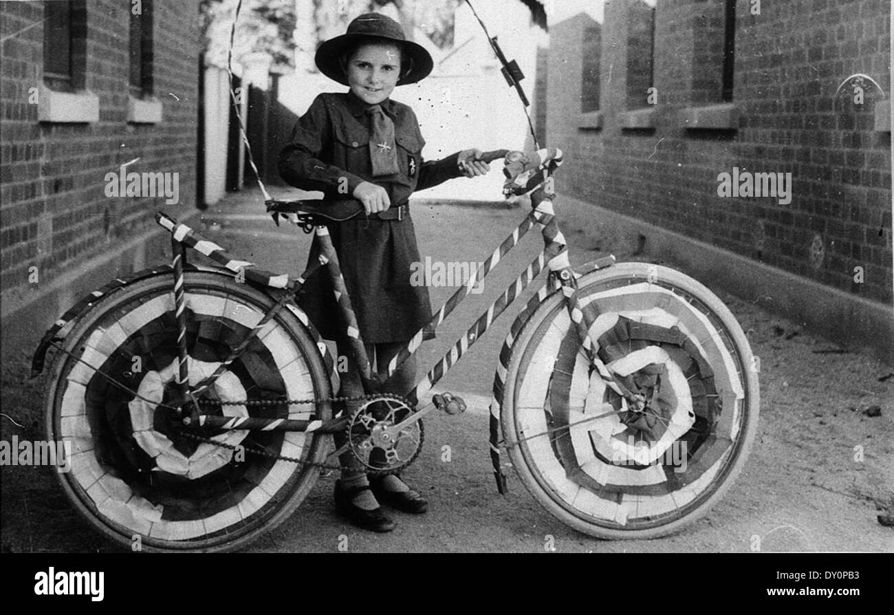 Dieses Foto zeigt Muriel Long, bekannt als Brownie, mit ihrem Fahrrad für eine Straßenprozession in Deniliquin, New South Wales. Das Bild fängt einen festlichen Moment ein und zeigt Gemeindefeiern und lokale Bräuche im ländlichen Australien. Stockfoto