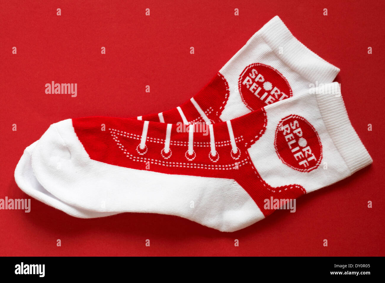 paar von roten und weißen Sport Relief Socken isoliert auf rotem Grund Stockfoto