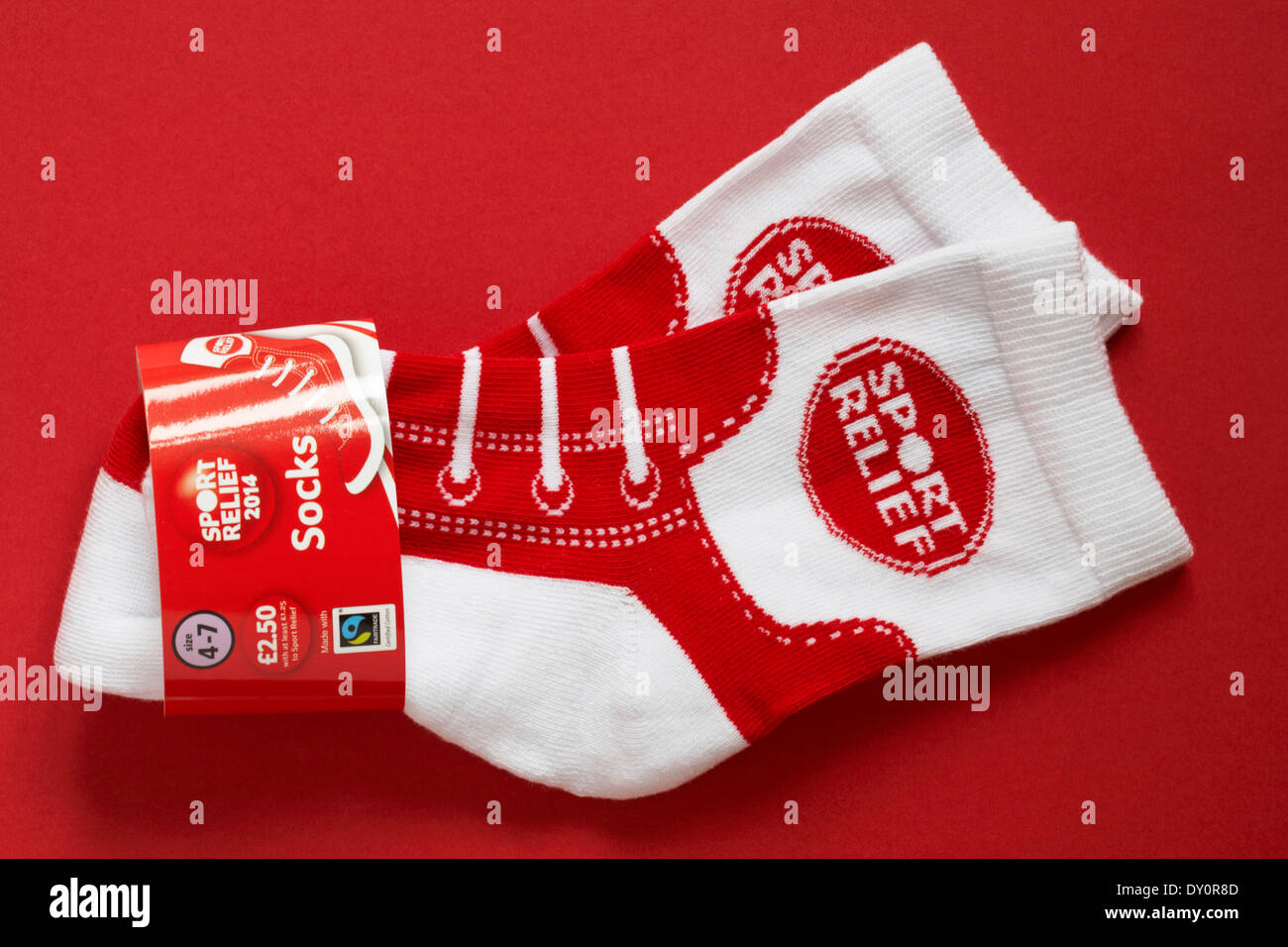 paar von roten und weißen Sport Relief Socken isoliert auf rotem Grund Stockfoto