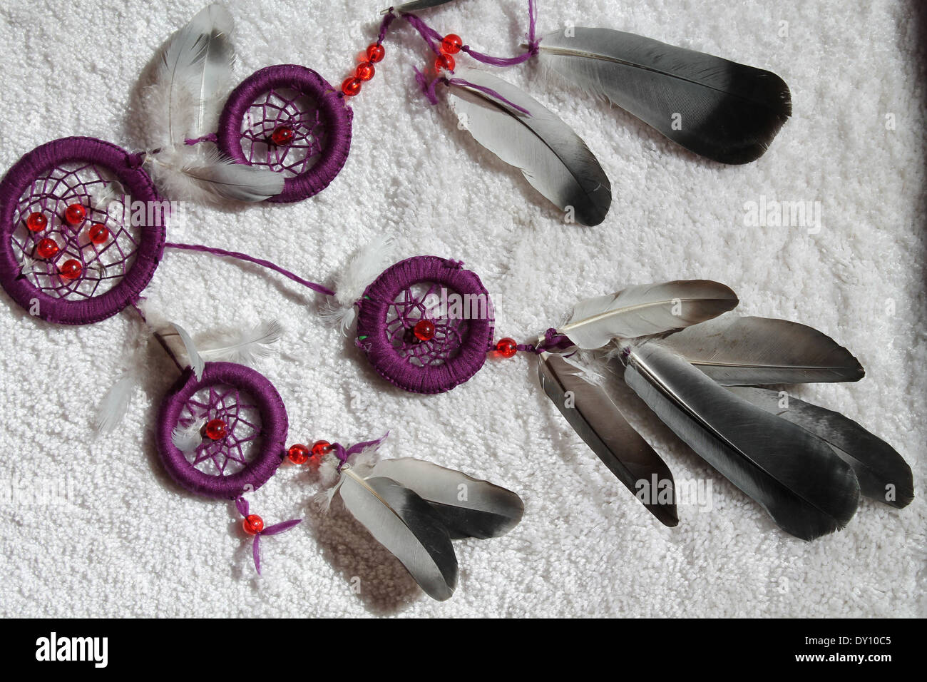 violette Dreamcatcher aus Federn und Perlen lag auf dem weißen Stockfoto