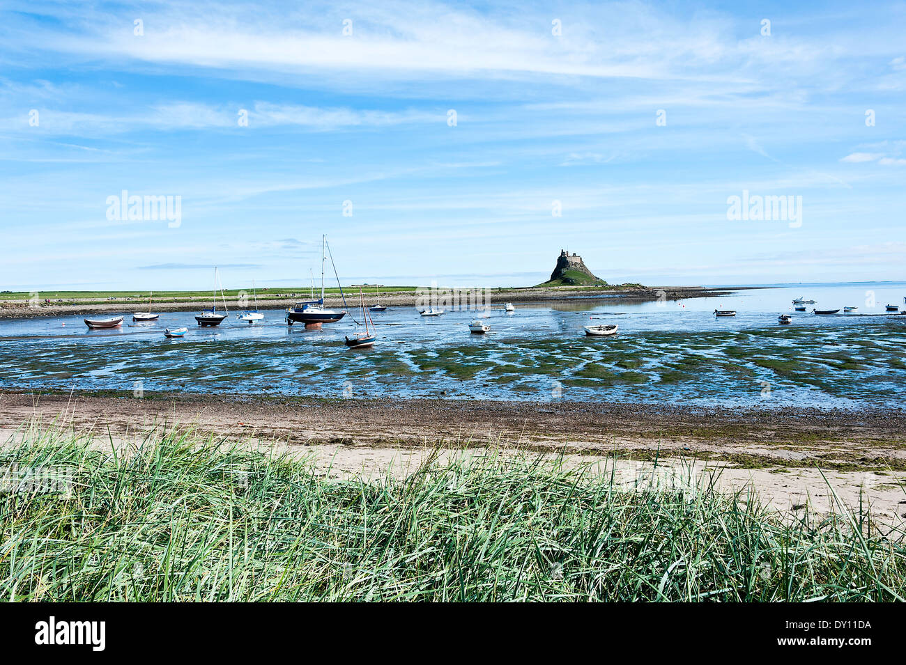 Lindisfarne Schloß [heilige Insel] und Hafengebiet mit festgemachten Boote und Reflexionen im Meer Northumberland England UK Stockfoto