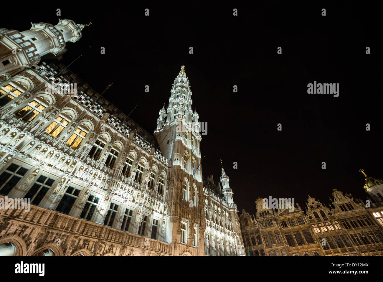 Grand Place beleuchtet bei Nacht Brüssel Belgien // BRÜSSEL, Belgien – die historischen Gebäude des Grand Place sorgen durch sorgfältig gestaltete architektonische Beleuchtung für eine dramatische nächtliche Darstellung. Die mittelalterlichen und barocken Fassaden des UNESCO-Weltkulturerbes leuchten am Abendhimmel und heben ihre kunstvollen architektonischen Details hervor. Der beleuchtete Platz verwandelt Brüssels wichtigste Touristenattraktion in ein nächtliches Theaterspektakel. Stockfoto