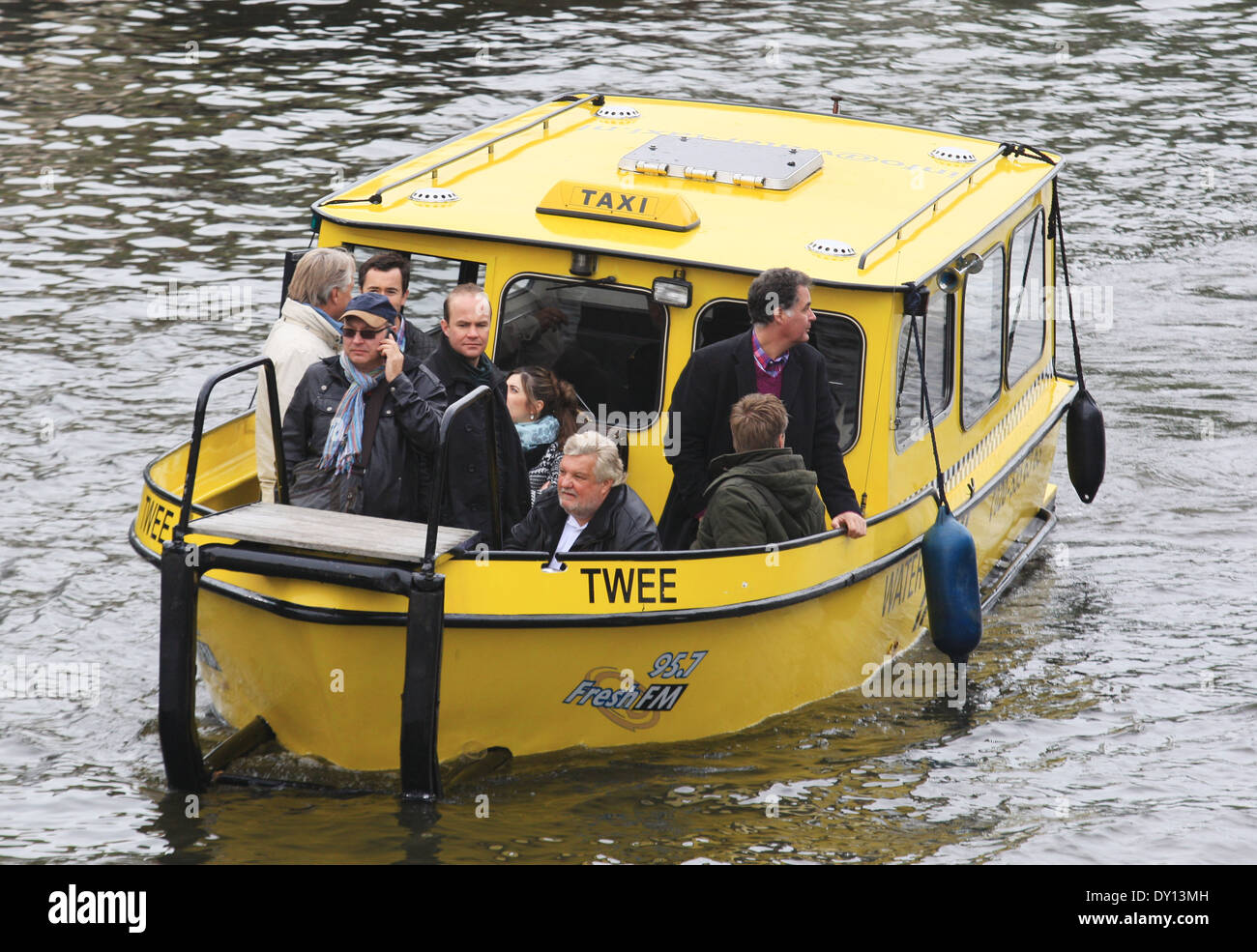 Menschen am gelben Wasser-Taxi am Kanal in Amsterdam, Niederlande Stockfoto