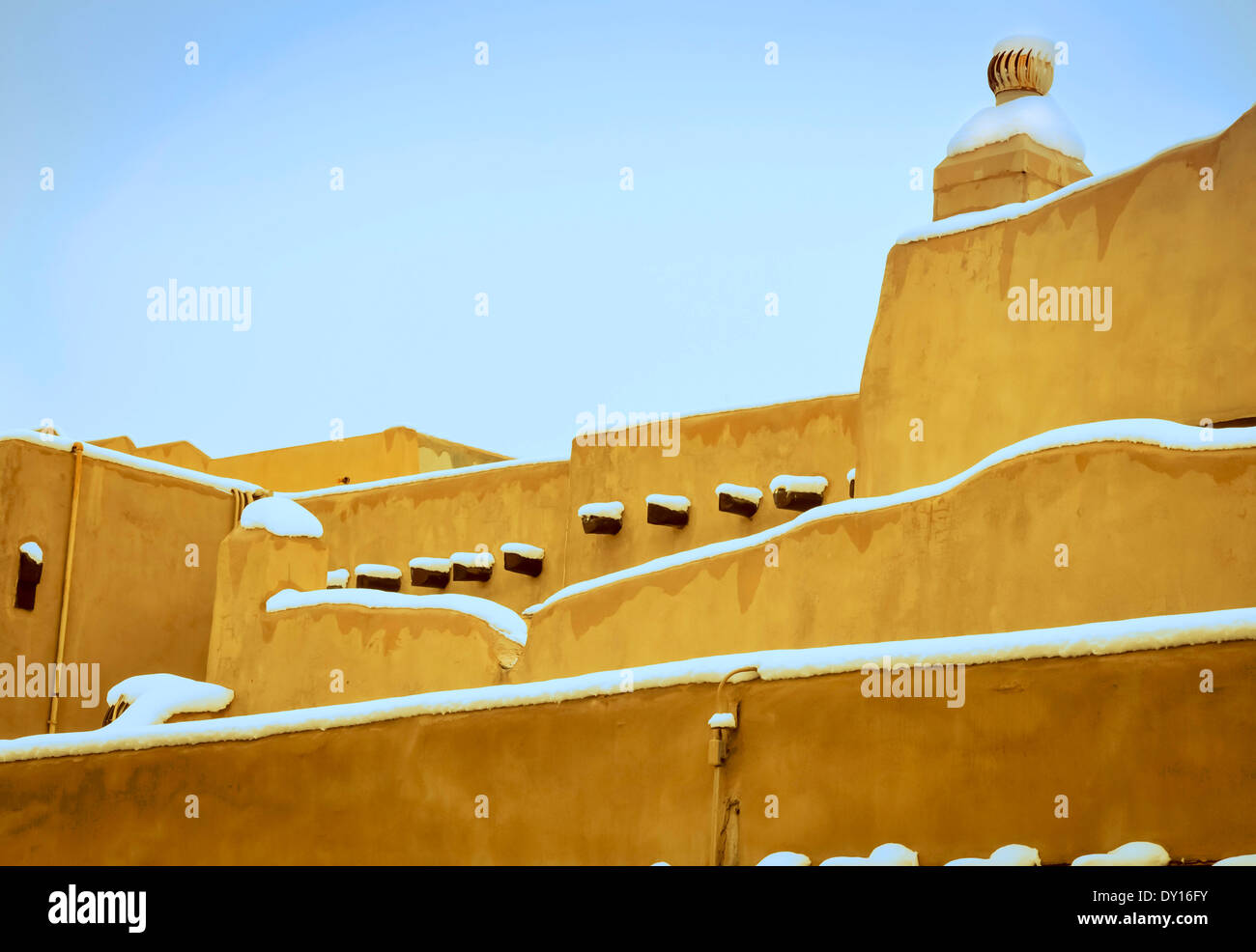 Eine malerische Vision von schrägen Adobe Dächern sprießen Vigas während bedeckt von Schnee in Santa Fe, NM Stockfoto