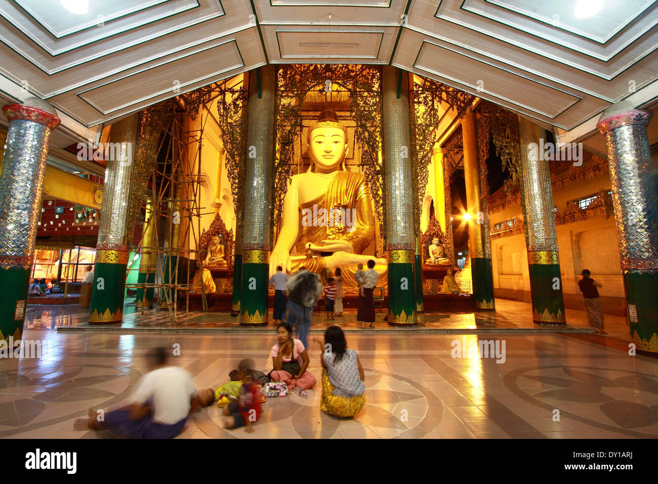 nicht identifizierte Burmesen sitzen vor großen Buddha-Statue am Shwedagon Pagada Stockfoto