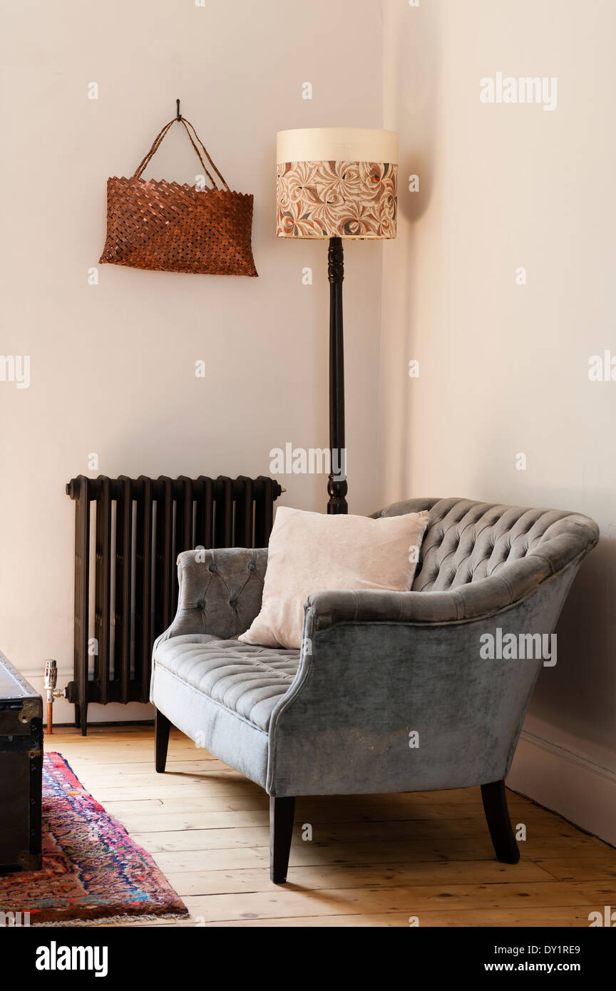 Grau mit Knöpfen Sofa von alten altmodischen Heizkörper und Stehlampe mit Schatten von Cassandra Ellis auf freiem Fuß Stockfoto