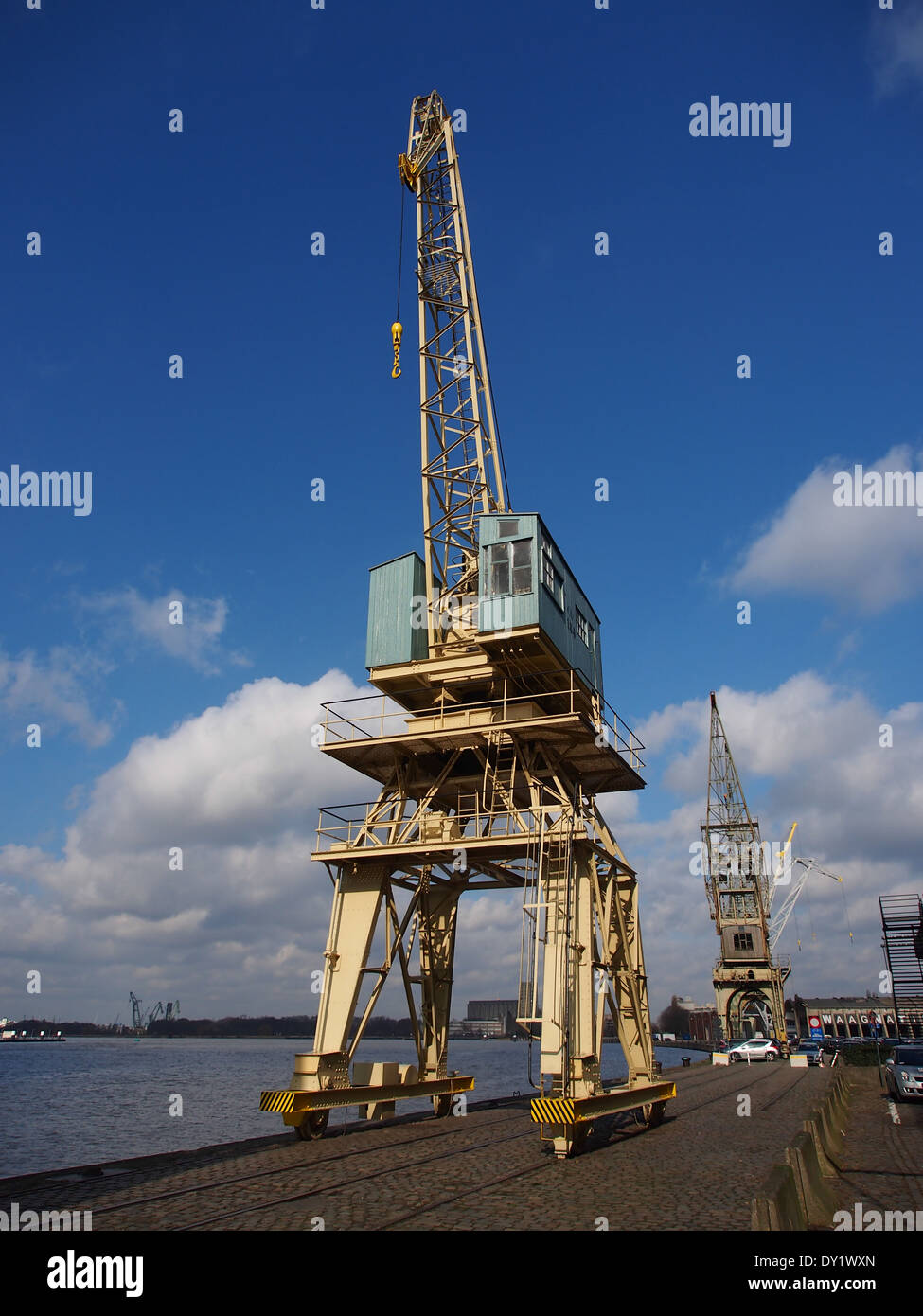 Der Antwerpener Hafen, einer der belebtesten Häfen Europas, verfügt über alte Hafenkräne, die noch heute in Betrieb sind. Diese Kräne sind integraler Bestandteil des effizienten Frachtumschlags im Hafen und symbolisieren die lange Geschichte der Antwerpener Seeverkehrsbranche. Stockfoto