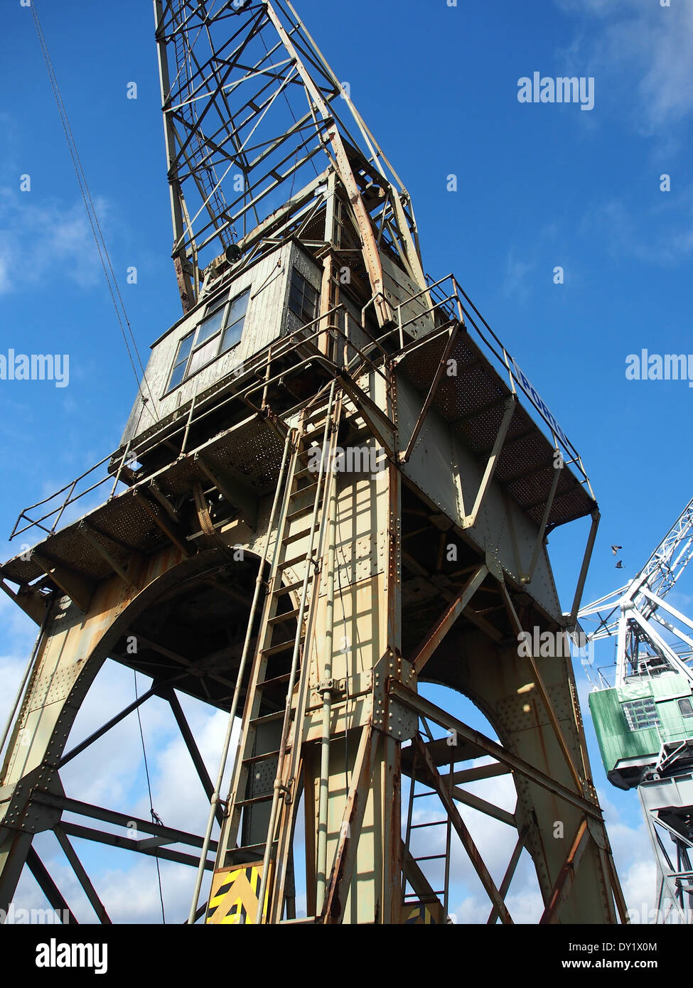 Alte Hafenkräne stehen im Antwerpener Hafen, einem wesentlichen Teil der Infrastruktur für das Be- und Entladen von Gütern. Diese Kräne, die mehrere Jahrzehnte zurückreichen, symbolisieren die lange Geschichte der Stadt als einer der geschäftigsten Seehäfen Europas und erleichtern den globalen Handel. Stockfoto