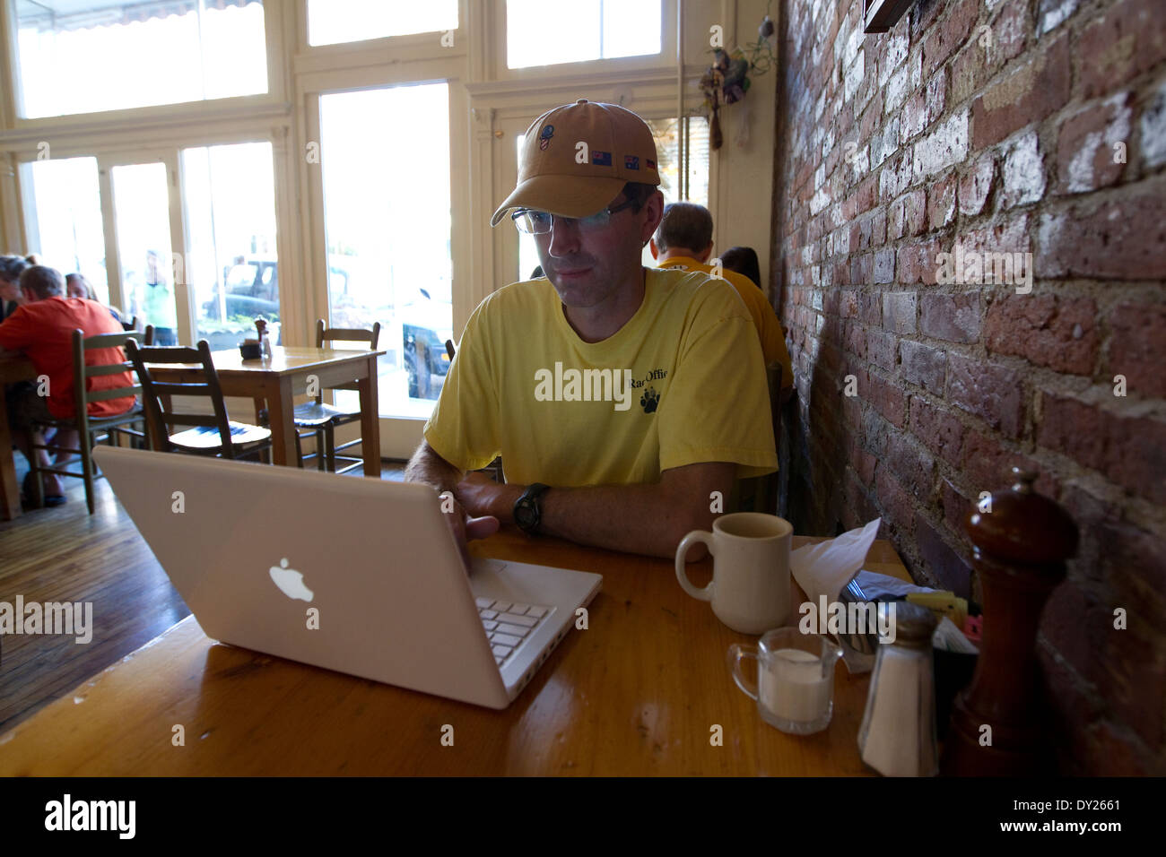 Mann in belebten Café nutzt Computer Laptop beim Kaffeetrinken Stockfoto